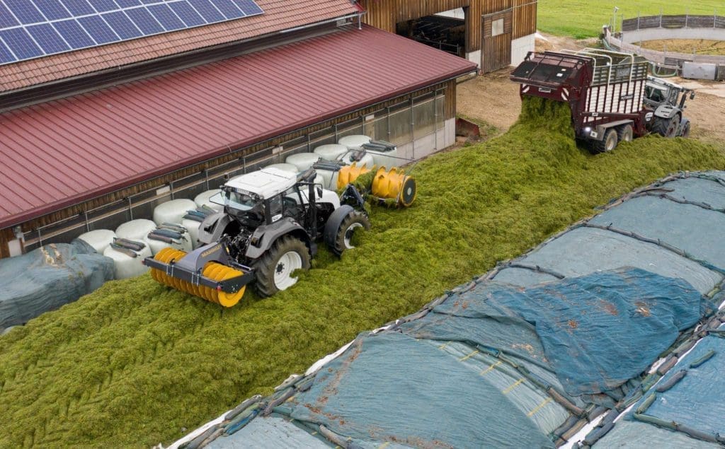 Silage roller and silage spreader during ensiling on the tractor - loading wagon silage