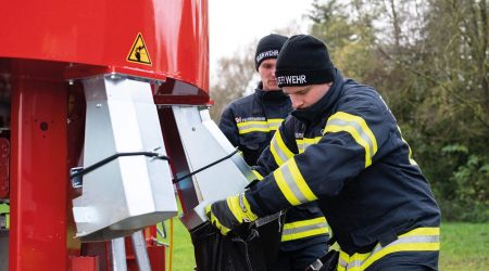 Firefighter operating the patented bagging system - MAMMUT sandbag filling machine