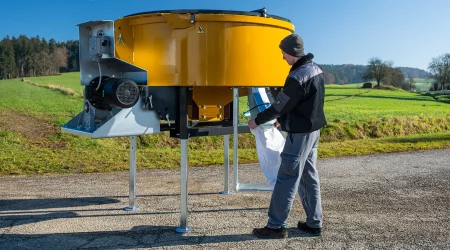 MAMMUT TURBO MIX pan mixer, person filling sandbag with Qick Fill sandbag filling spout and electric motor