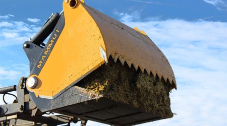 Kuilhapper met dichte bodem SILO BUCKET bij het vullen van een voermengwagen